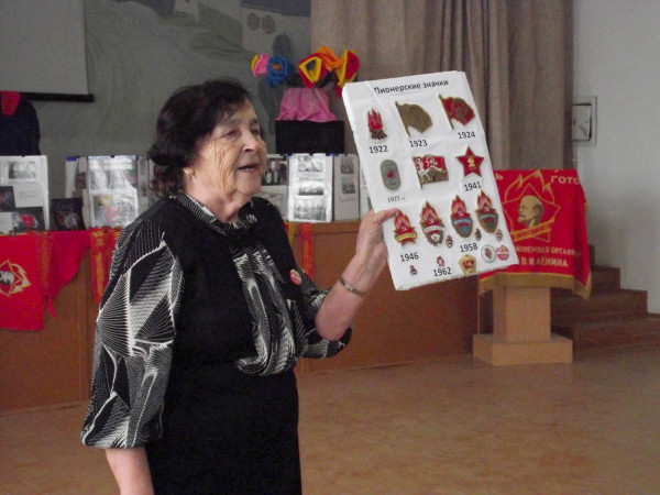 Мария Антипина рассказывает о пионерской атрибутике на выездном мероприятии, захватив с собой «музей в чемодане»